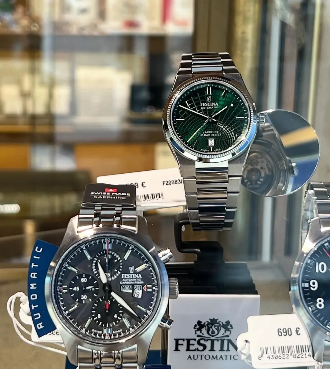 Due orologi Festina automatici in acciaio, quadrante verde e quadrante nero cronografo, in vetrina