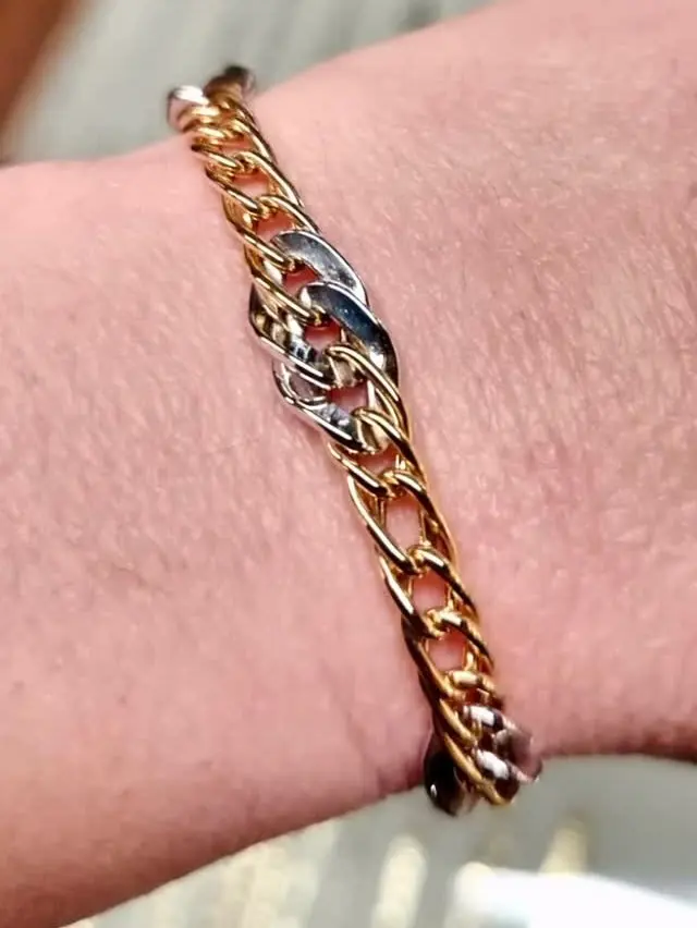 Un bracciale da donna a maglie groumette in oro bianco e giallo, al polso