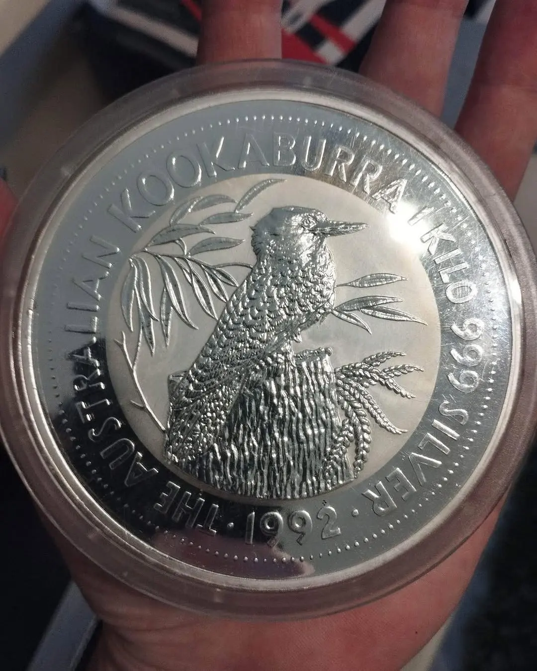 La moneta d'argento Kookaburra del 1992 da un chilo, nella sua capsula, tenuta in mano